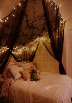 a bed with some lights hanging from the ceiling and pillows on it's side