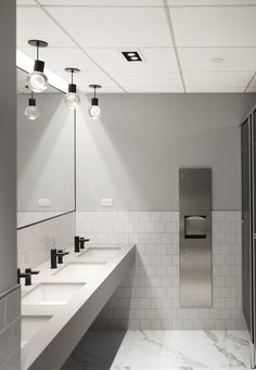 a public restroom with two sinks and three urinals on the wall next to each other