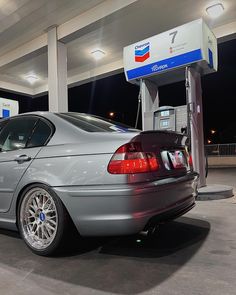 a silver car is parked at a gas station