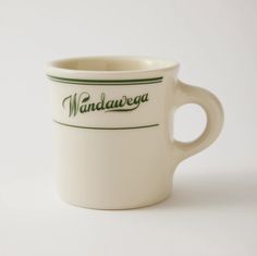 a white coffee cup with the word wanddawea on it's side