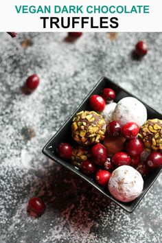 a bowl filled with fruit and nuts on top of a gray table next to red berries