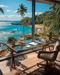 a desk with a view of the ocean and palm trees in front of an open window