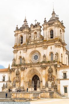 an old church with statues on the front and stairs leading up to it's entrance