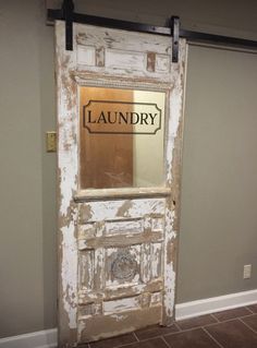 an old door with the words laundry on it and a mirror in front of it