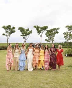 a group of women standing next to each other on top of a lush green field