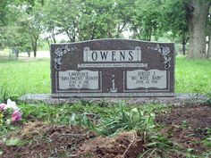 a headstone in the middle of some grass