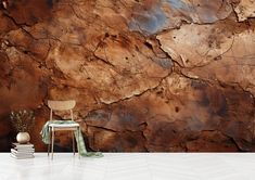 a chair sitting in front of a wall covered in brown and blue paint, with a potted plant next to it