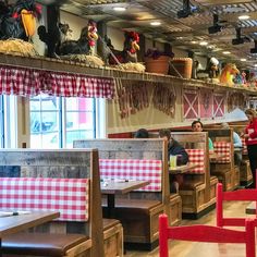 people sitting at tables in a restaurant with red and white checkered tablecloths