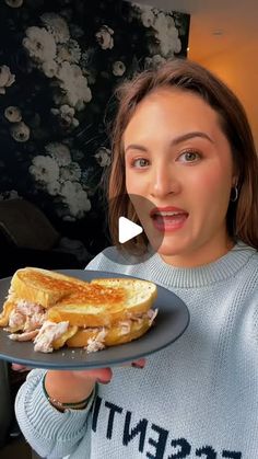 a woman holding a plate with some food on it