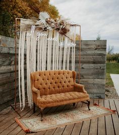 a couch sitting on top of a wooden floor next to a wall covered in white string