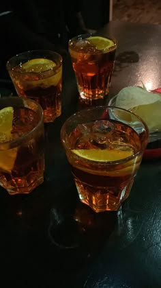 three glasses filled with liquid sitting on top of a table