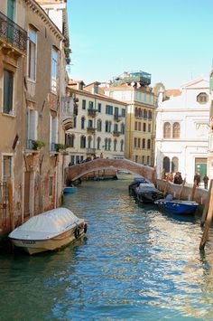 several boats are parked along the side of a canal