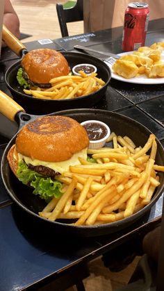 two trays with hamburger and french fries on them