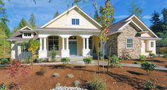 a house that is in the middle of some dirt and grass with trees around it