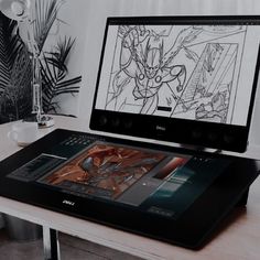 a laptop computer sitting on top of a desk next to a drawing pad and mouse