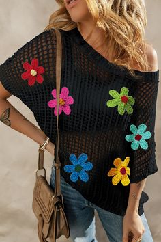 a woman wearing a black crochet top with colorful flowers on the shoulders and shoulder