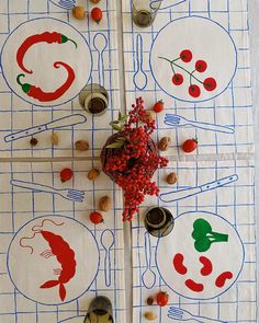 the table cloth is decorated with red berries and other food items on white linens