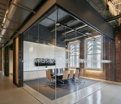 an empty conference room with glass walls and chairs