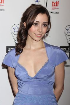 a woman in a blue dress posing for a photo on the red carpet at an event