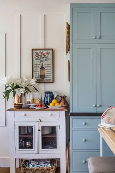 a kitchen with blue cabinets and white flowers