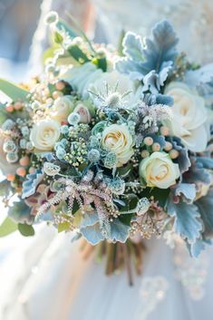 a bridal holding a bouquet of white and blue flowers