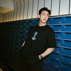 a young man standing in front of blue lockers