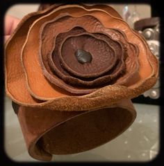 This gorgeous tough flirty yet totally feminine, just over 2" wide leather cuff.  A beautiful cuff with a leather flower that appears to be blossoming straight out of the cuff.  This cuff is not for the faint of heart as it is a statement piece.  This one of a kind cuff is going to be your go to piece in your accessories collection.  Wear it well Unique Leather Cuff Bracelet, Elegant Brown Cuff Leather Bracelet, Unique Brown Cuff Jewelry, Adjustable Leather Cuff Bracelet, Elegant Style, Unique Hand-tooled Leather Cuff Bracelet, Leather Flower, Leather Flowers, Accessories Collection, Homemade Jewelry