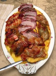 a white plate topped with meat covered in sauce