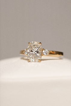 a yellow gold engagement ring with an oval cut diamond