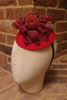 Little Hats for Grand Occasions. Glittery red bow and berry design christmas pillbox fascinator. Perfect for the festive season and  christmas weddings. Embellishments, feathers, buttons and brooches are lovingly sourced for unique individual pieces. Hats are 16cm by 13.5cm and dispatched in a box. 2 clips and a headband are provided for ease of fixing in place.  Handmade in the UK. No two designs are the same. Please message me to discuss any personal requirements. Return and exchanges except within 14 days. Please read the full details in the FAQS. Many more designs on the shop. Christmas Fascinator, Pillbox Fascinator, Company Christmas Party, Tea Hats, Christmas Weddings, Holiday Hats, Christmas Glitter, Wedding Fascinators, Christmas Tea