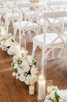 white flowers and candles are lined up on the floor