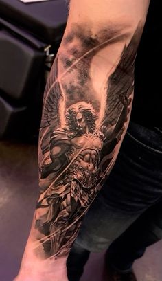 a man's arm with an angel and demon tattoo on the left side of his leg