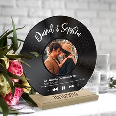 a personalized record with an image of a man and woman on it next to flowers