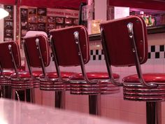 a row of red chairs sitting on top of a counter