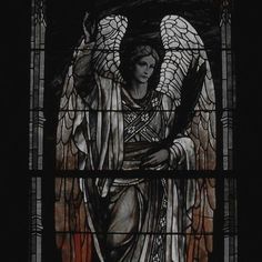 a stained glass window with an angel holding a cross