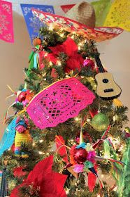 a christmas tree decorated with colorful decorations and musical instruments hanging from it's sides