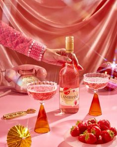 a pink table topped with lots of food and drinks