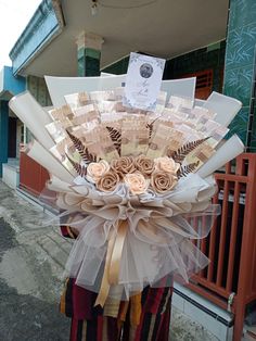 a person holding a bouquet of flowers in front of a building