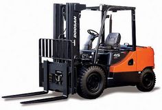 an orange forklift parked on top of a white floor next to a black fork lift