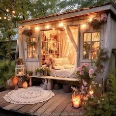 an outdoor room with lights on the windows and flowers in potted plants next to it