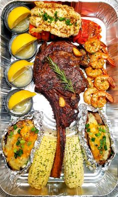 a platter filled with different types of seafood and other foods on tinfoil covered trays