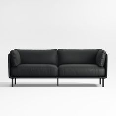 a black leather couch sitting on top of a white floor