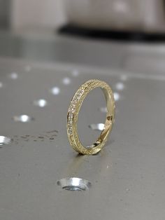 a gold wedding ring sitting on top of a table