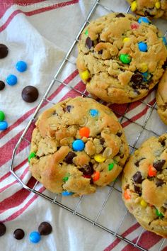 chocolate chip cookies with m & m and candy on the top are cooling on a wire rack