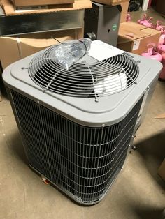 an air conditioner sitting on top of a floor next to boxes