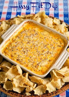 a bowl filled with cheese dip surrounded by chips