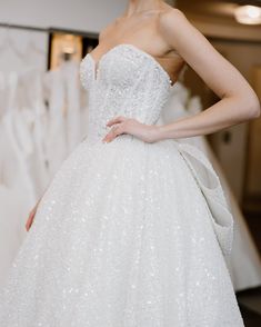 Close-up of a bride in a sparkly designer luxury wedding dress. Structured Skirt, Intricate Beading, Sparkle Wedding Dress, Strapless Neckline, Luxury Wedding Dress