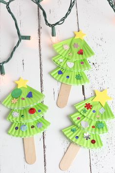 paper plate christmas tree craft for kids with string lights on the side and white wood background