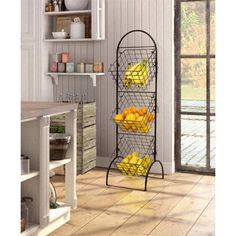 a metal rack filled with yellow fruit on top of a wooden floor next to a window