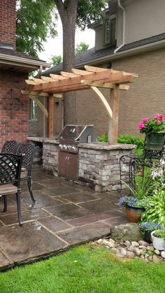 an outdoor kitchen with grill and seating area